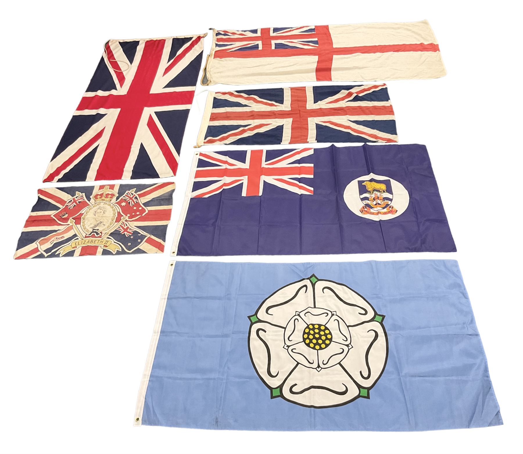 Six flags - White Ensign 180 x 86cm; two Union flags 180 x 86cm and 132 x 62cm; Falklands Islands 153 x 89cm; Yorkshire Rose 153 x 89cm; and QEII 1953 Coronation 84 x 57cm (6)