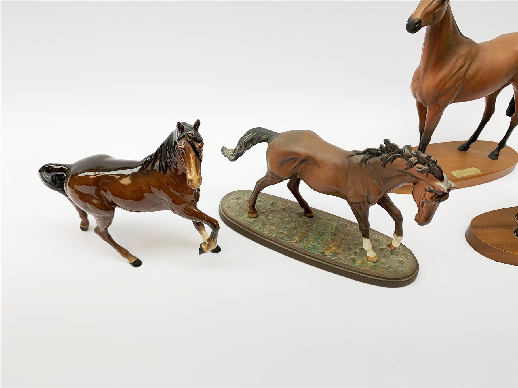 Four Royal Doulton horse figurines, comprising Red Rum, Arkle, and the Winner DA154, and another modelled as a prancing bay horse, largest H32cm. (4). 
