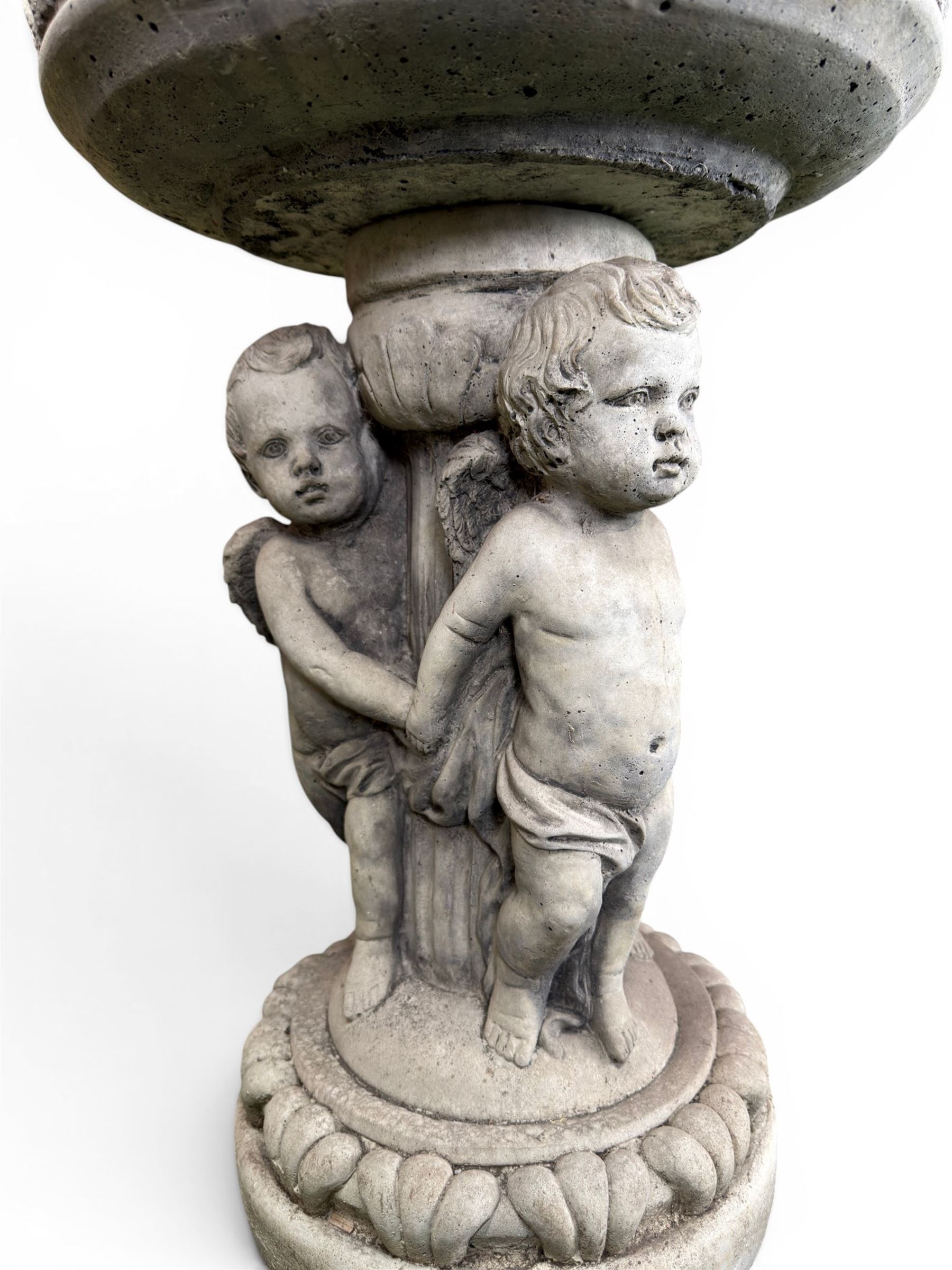 Cast stone cherub bird bath, circular removable top raised on three cherubs with ornate detailing