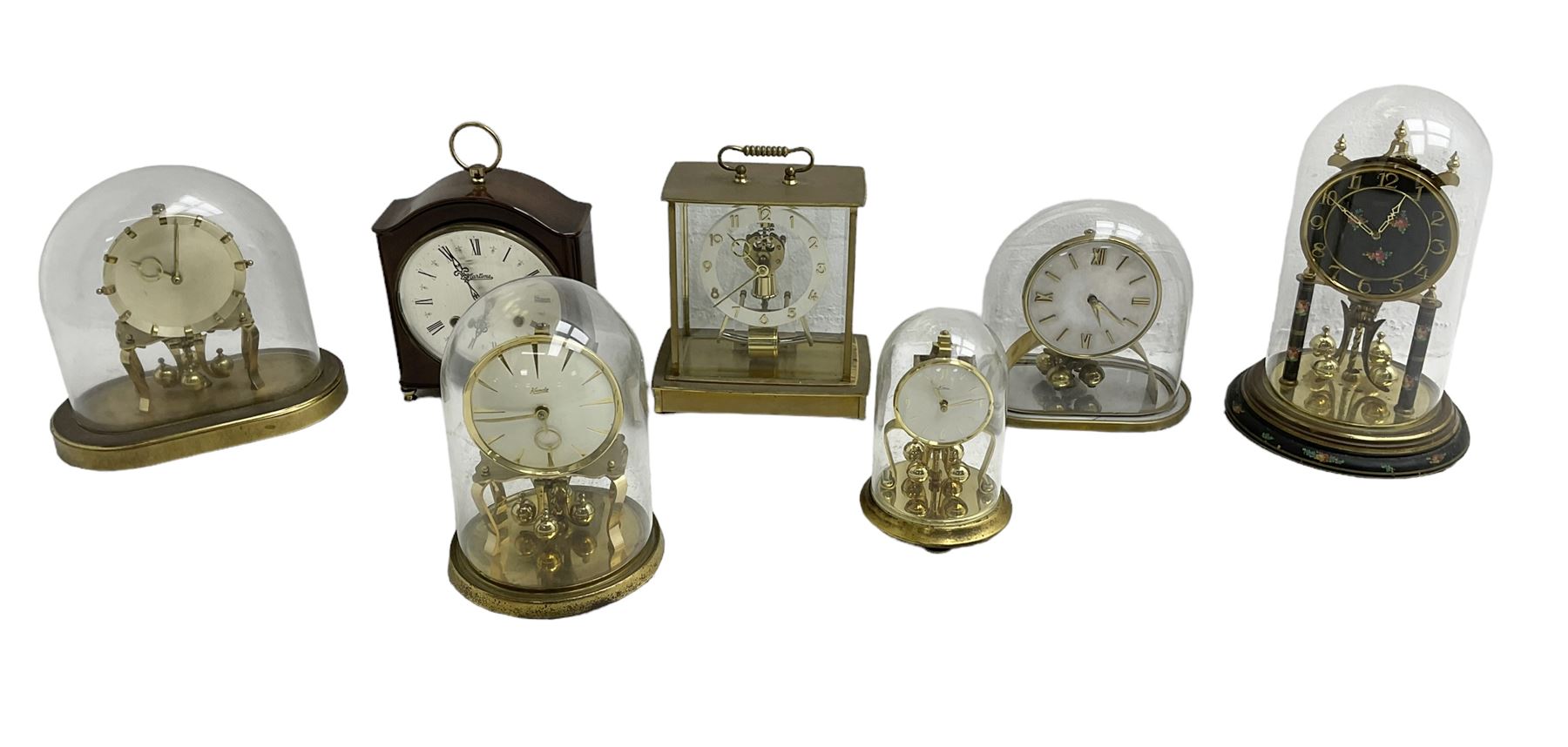 Five 20th century torsion clocks, a striking mantle clock and a Kundo battery operated mantle clock with a solenoid oscillating pendulum.