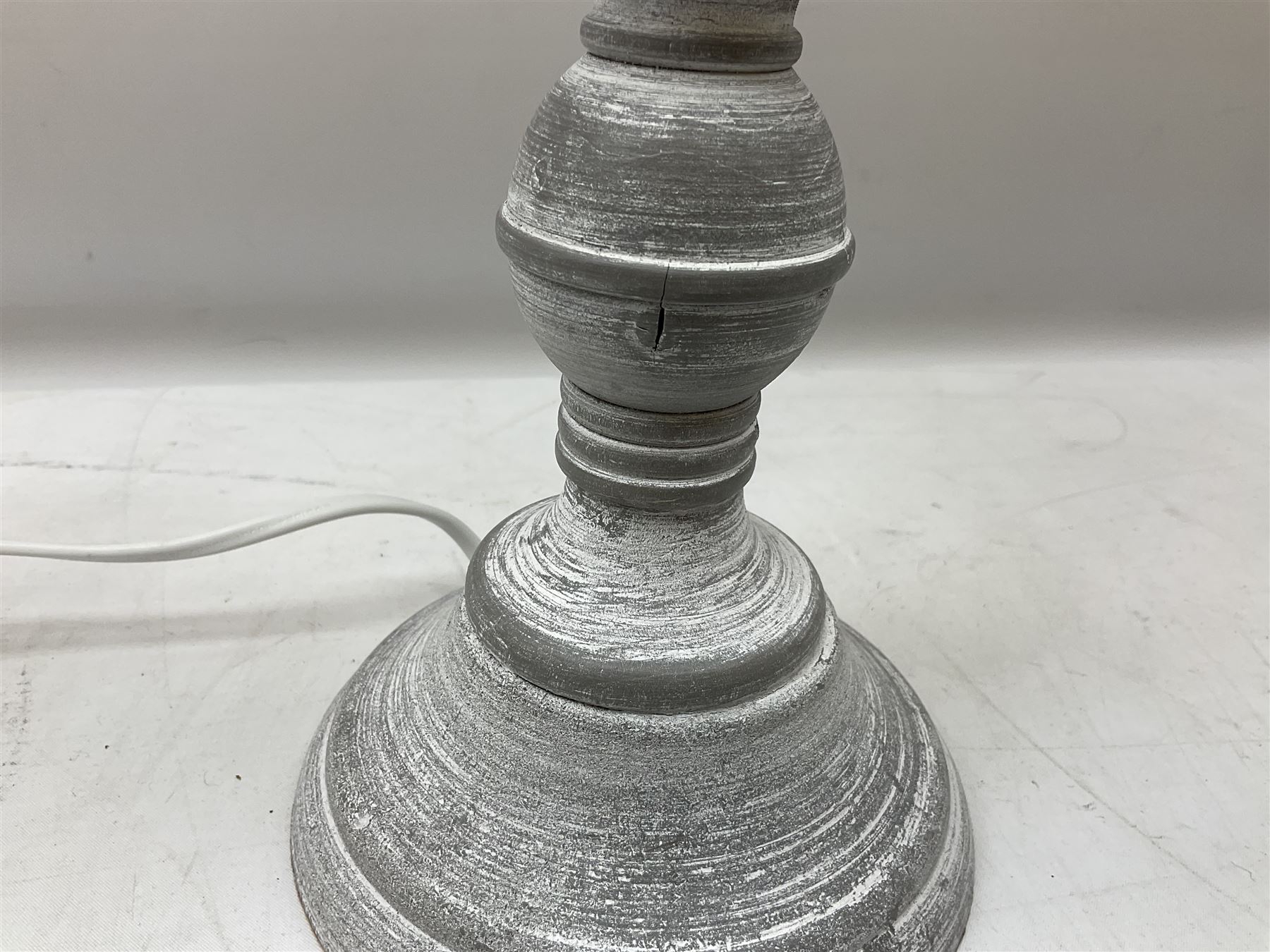 Pair of composite grey washed table lamps with a slender column upon a circular foot with natural linen shades