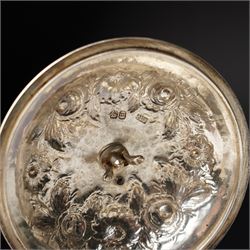 Matched three piece silver tea set comprising teapot of squat circular form London 1827,  milk jug of similar date and sugar bowl with Britannia standard marks, all with later embossed floral decoration and coat of arms, all marks rubbed