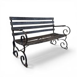 19th century wrought iron strapwork and slatted wood garden bench, the arm terminals and e...