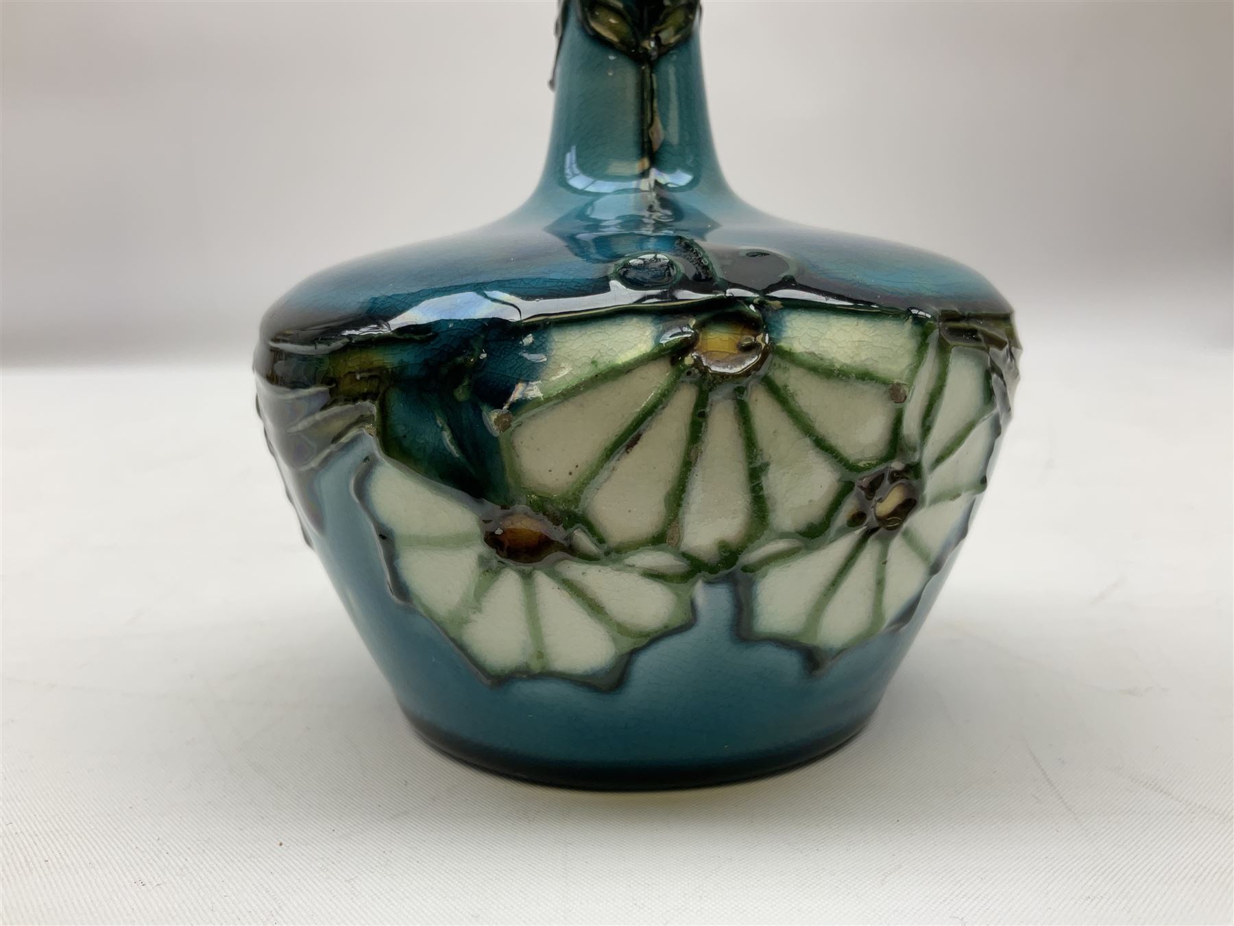 Minton Secessionist vase, with tube-lined stylised flower decoration, upon a blue ground, with printed mark to base 'Minton Ltd, No. 32', H13cm