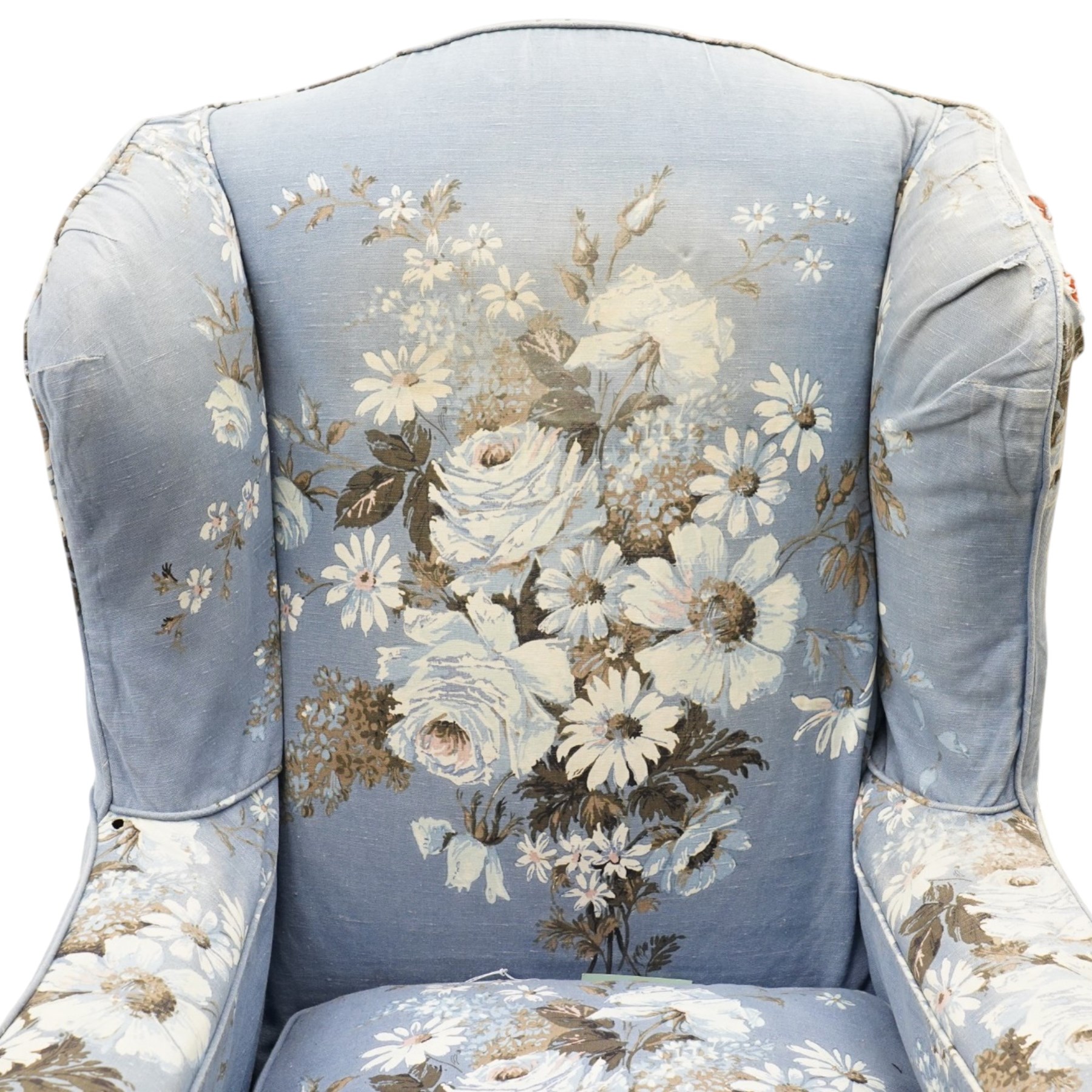 Pair of Queen Anne wingback armchairs, high back over out-swept arms, raised on ball-and-claw feet, upholstered in sky-blue ground floral chintz loose upholstery with pleated skirt and squab cushion