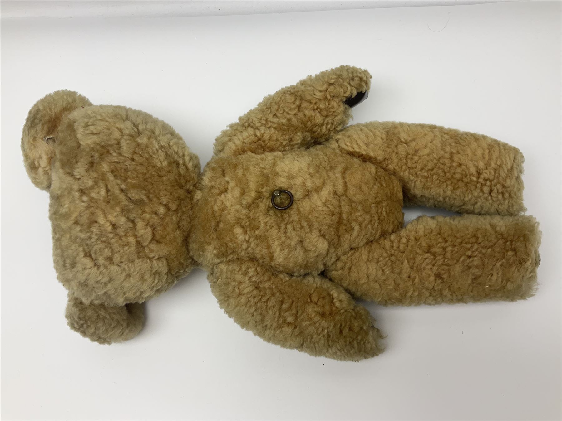 1950s sheepskin plush covered teddy bear with musical movement, the revolving head with applied eyes, leather nose and stitched mouth, jointed limbs with leather pads H50cm