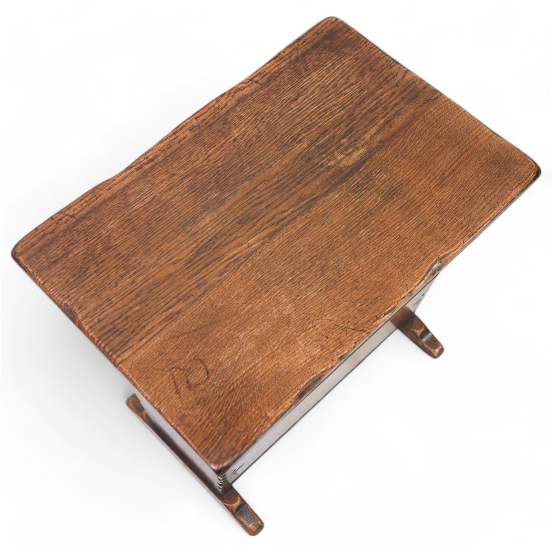 Oak magazine rack or side table, rectangular top on shaped end supports and sledge feet, panelled sides with chip carved decoration 