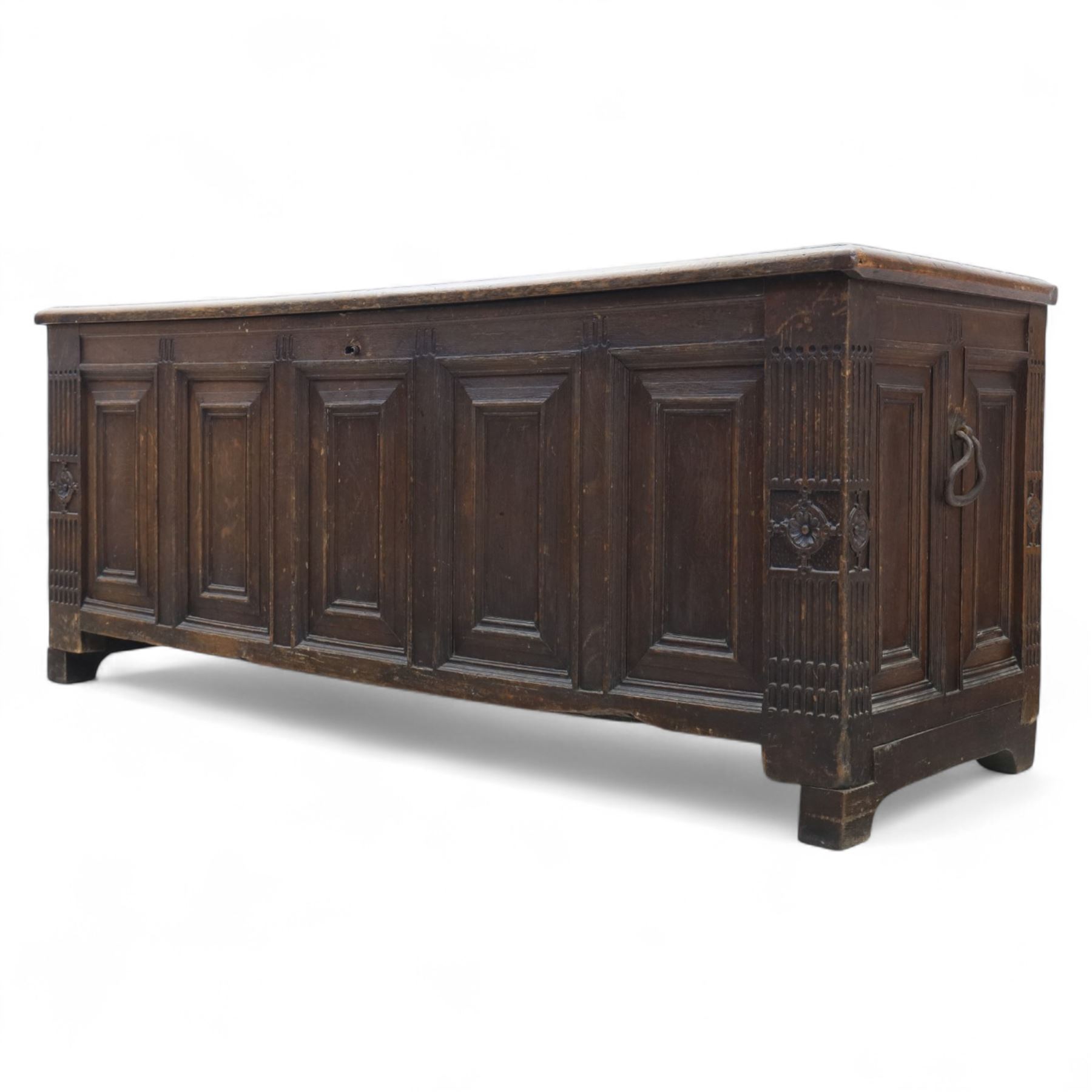18th century oak five panel chest, with planked top with chamfered edges, hinged top enclosing two candle boxes, five fielded panels flanked by foliate carvings, raised on stile supports