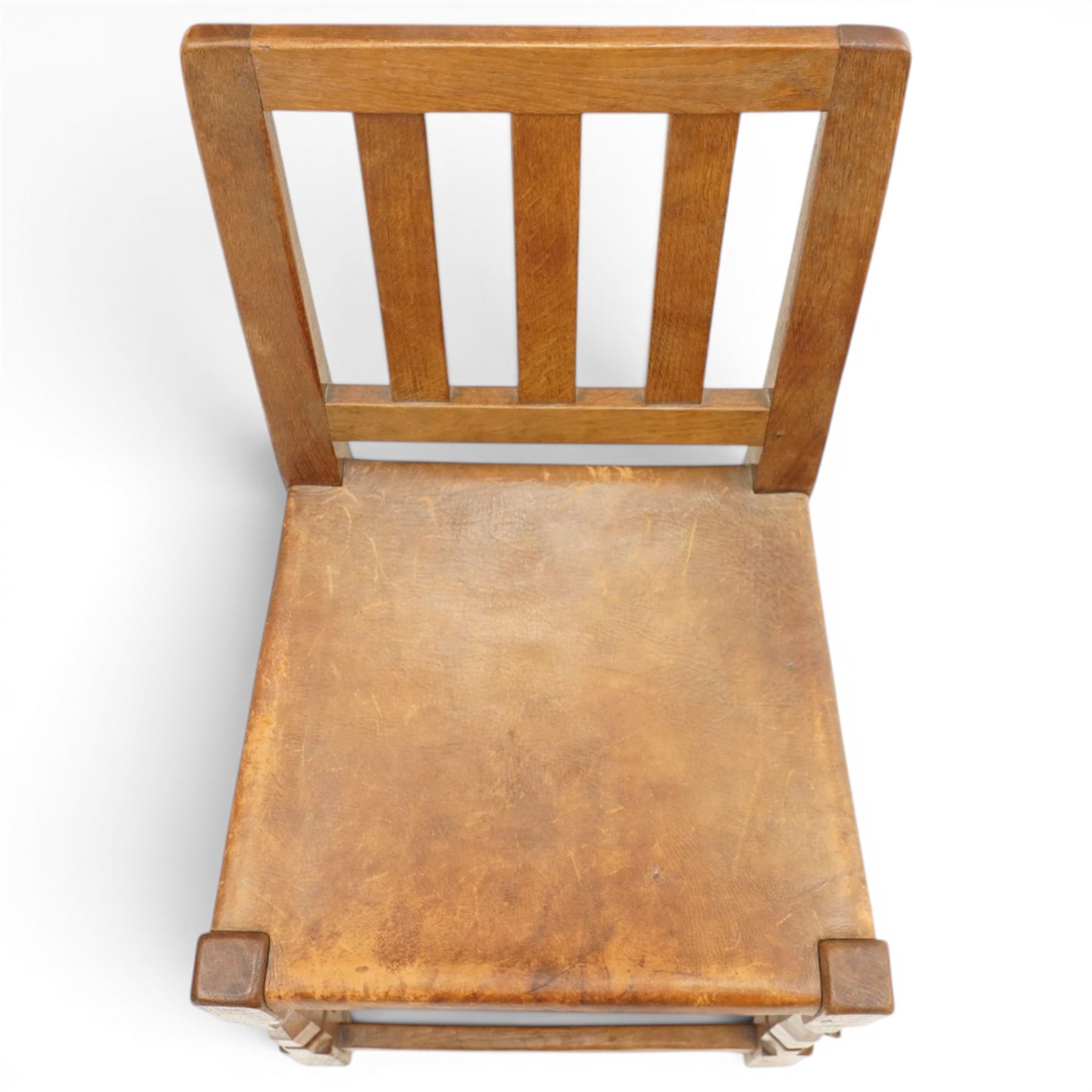 Mouseman - 1940s oak side chair, the slat-back over a slung leather seat, raised on octagonal front supports united by box stretcher, carved with slim mouse signature, by the workshop of Robert Thompson of Kilburn