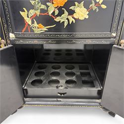 Early 20th century Chinoiserie lacquered cabinet, rounded rectangular top above a fall front enclosing fitted interior with lacquered decoration, over a pair of cupboard doors and flanked by side compartments with tiered bottle shelves, the black lacquer ground decorated throughout with raised and painted floral sprays, on shaped bracket feet