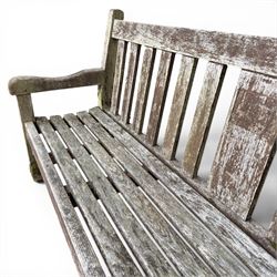 Teak garden bench with slatted back and seat on square supports in weathered which finish 