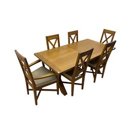Solid oak dining table on x-framed supports, and six dining chairs 