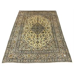 Persian Kashan golden ivory ground carpet, the central medallion surrounded by a field of interlacing branch and stylised plant motifs, the guarded border with scrolling design decorated with flower heads 