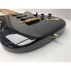 Copy of a Fender Stratocaster electric guitar in black with Wilkinson bridge, lock-in tuners, synchronised tremolo and various patent numbers; L99cm; in hard carrying case with strap and digital tuner
