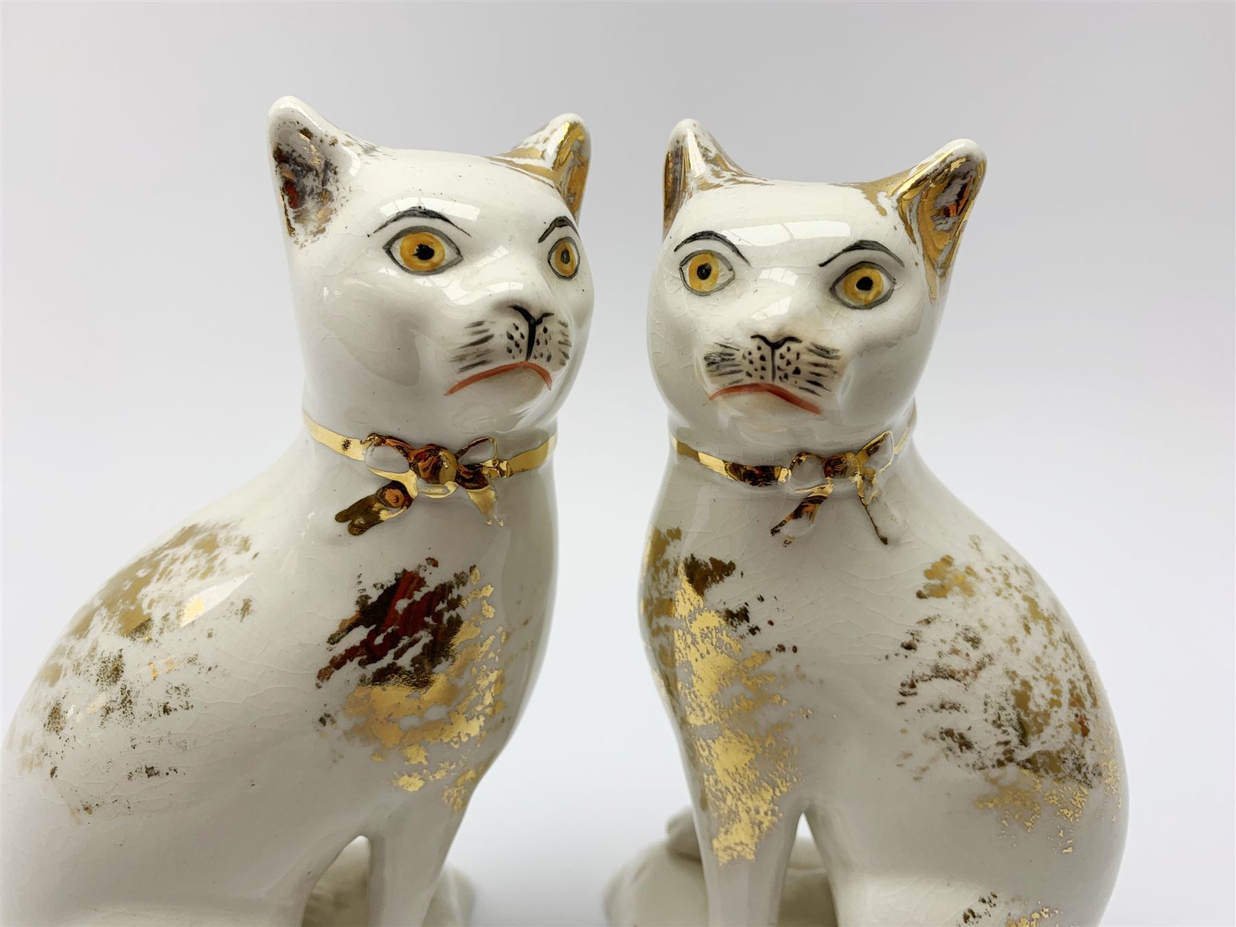 Pair of Victorian Staffordshire cats, modelled seated upon cushions, with gilt detail throughout, H18cm