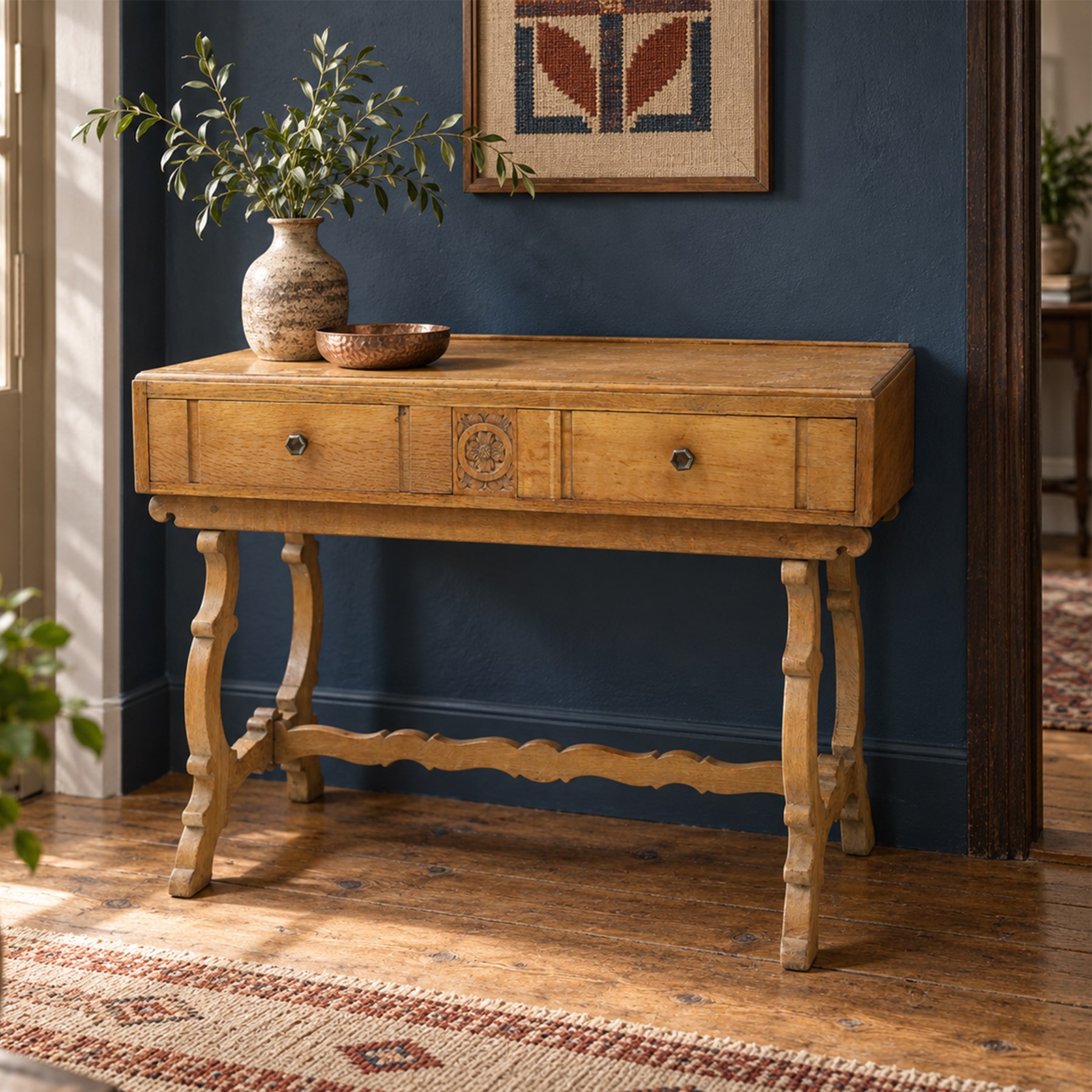 Leemings of Halifax (est. 1872) - Arts & Crafts oak side table, rectangular caddy top with raised moulded back, the frieze carved with central Yorkshire rose motif flanked by two drawers, raised on twin stylised lyre end supports formed of C-scrolls, united by shaped stretcher