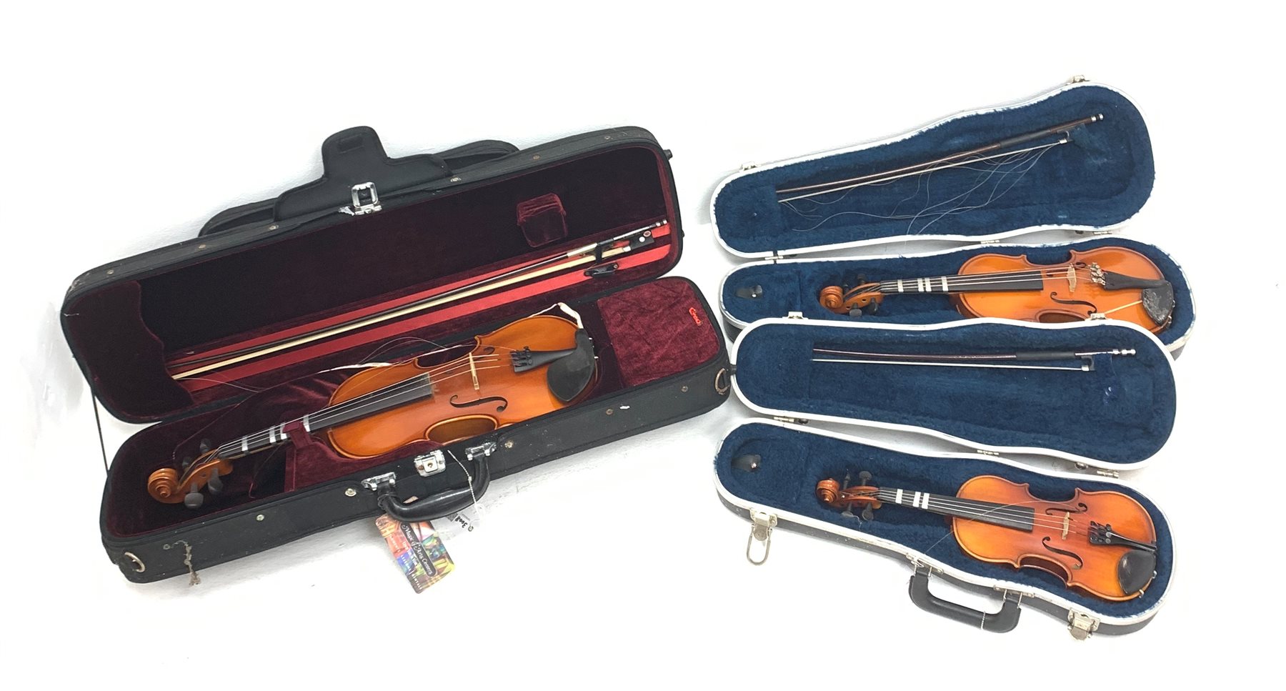 Three modern graduated violins - Suzuki 1/10 size child's violin with 23.5cm single piece back, bears label serial no.94282, 40cm overall; copy of Antonius Sradivarius of Cremona violin dated 1998 with 28cm two-piece back, 47cm overall; and Strobel violin with 35.5cm two-piece back, bears label dated 2006, serial no.512801325, 59cm overall. All cased with bows (3)
