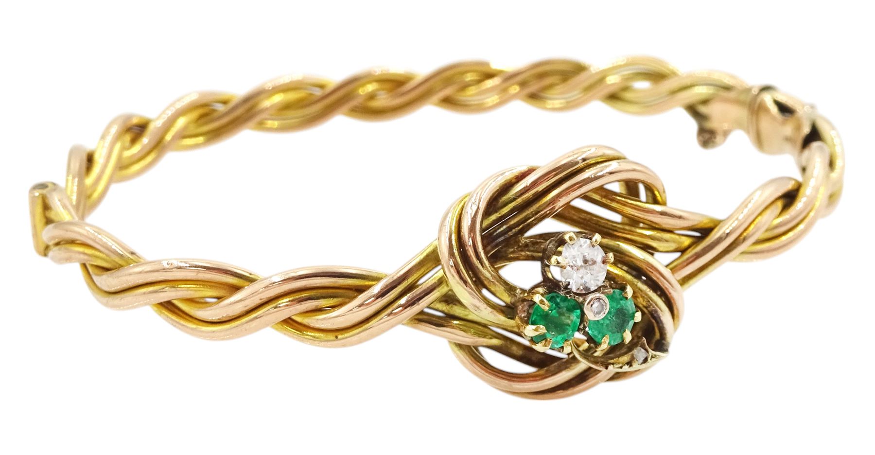 Early 20th century rose gold weave and knot hinged bangle, the central knot with old cut diamond and emerald three leaf clover decoration, stamped 9ct, diamond approx 0.15 carat