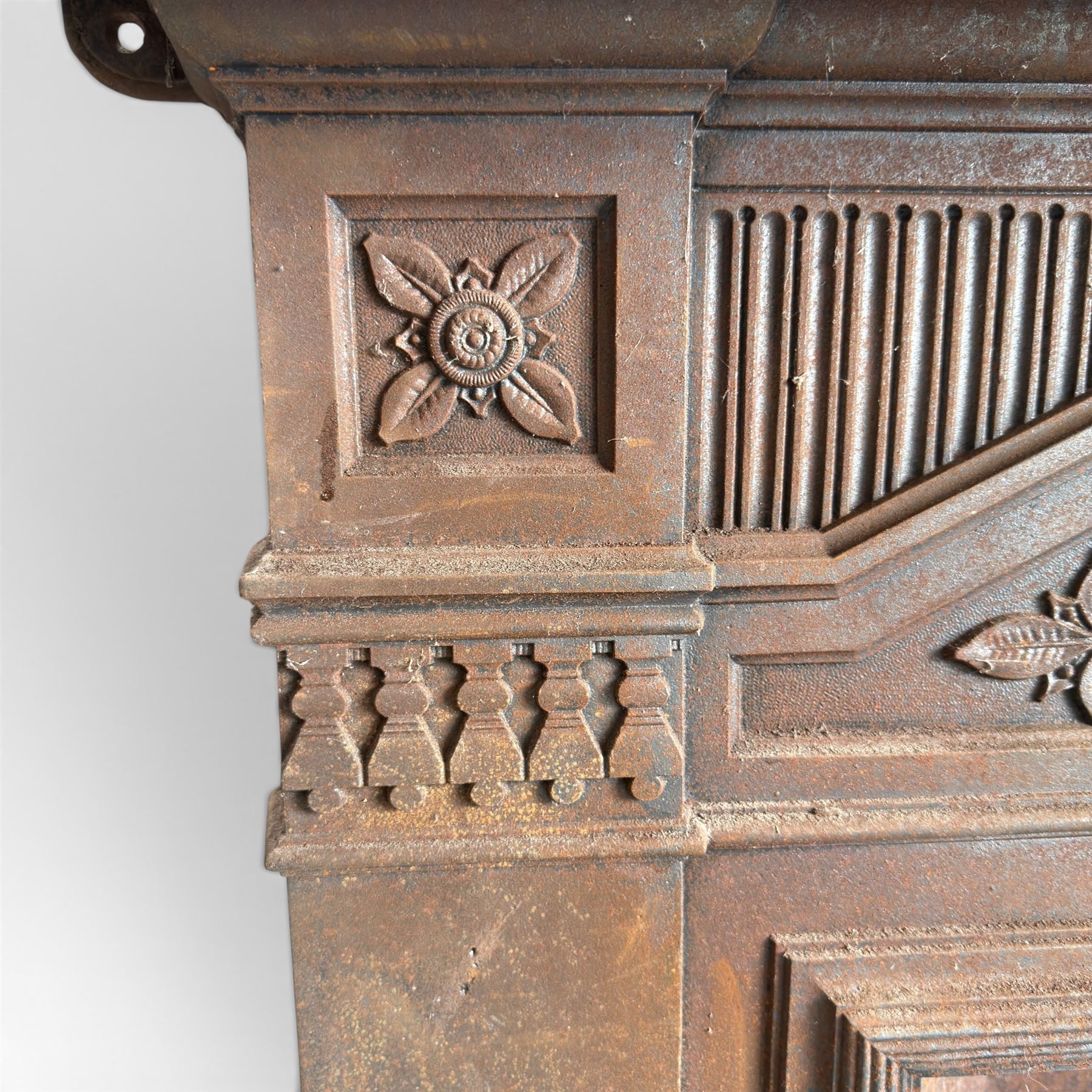 Late Victorian cast ion bedroom fireplace, decorated with floral poppy motifs and flluting