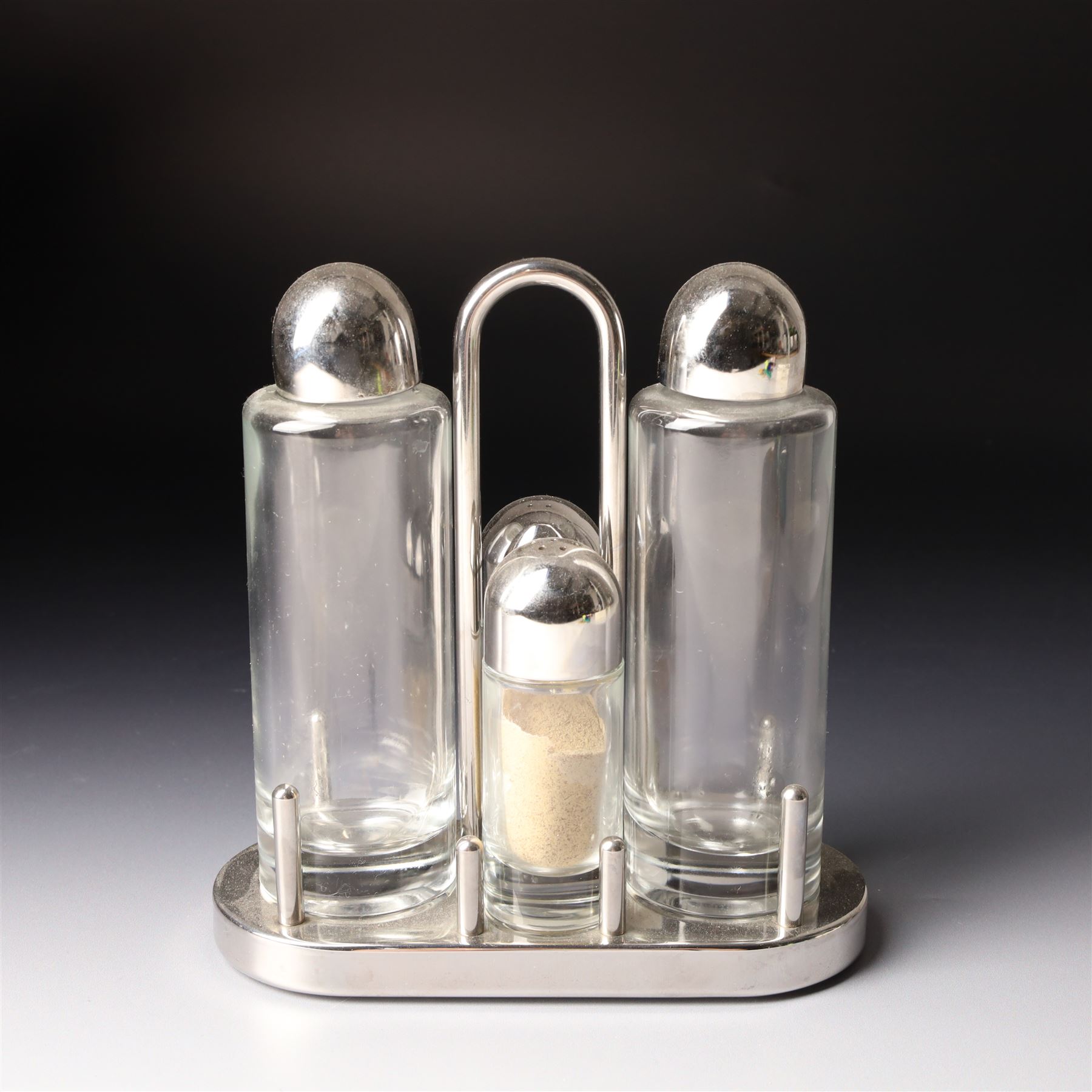 Collection of Alessi items, comprising a 'Juicy Salif' lemon squeezer designed by Philippe Starck, a condiment set designed by Ettore Sottsass, two 'Carlo - a ghost on top of a bottle' designed by Mattia Di Rosa, and further items, all stamped (10)