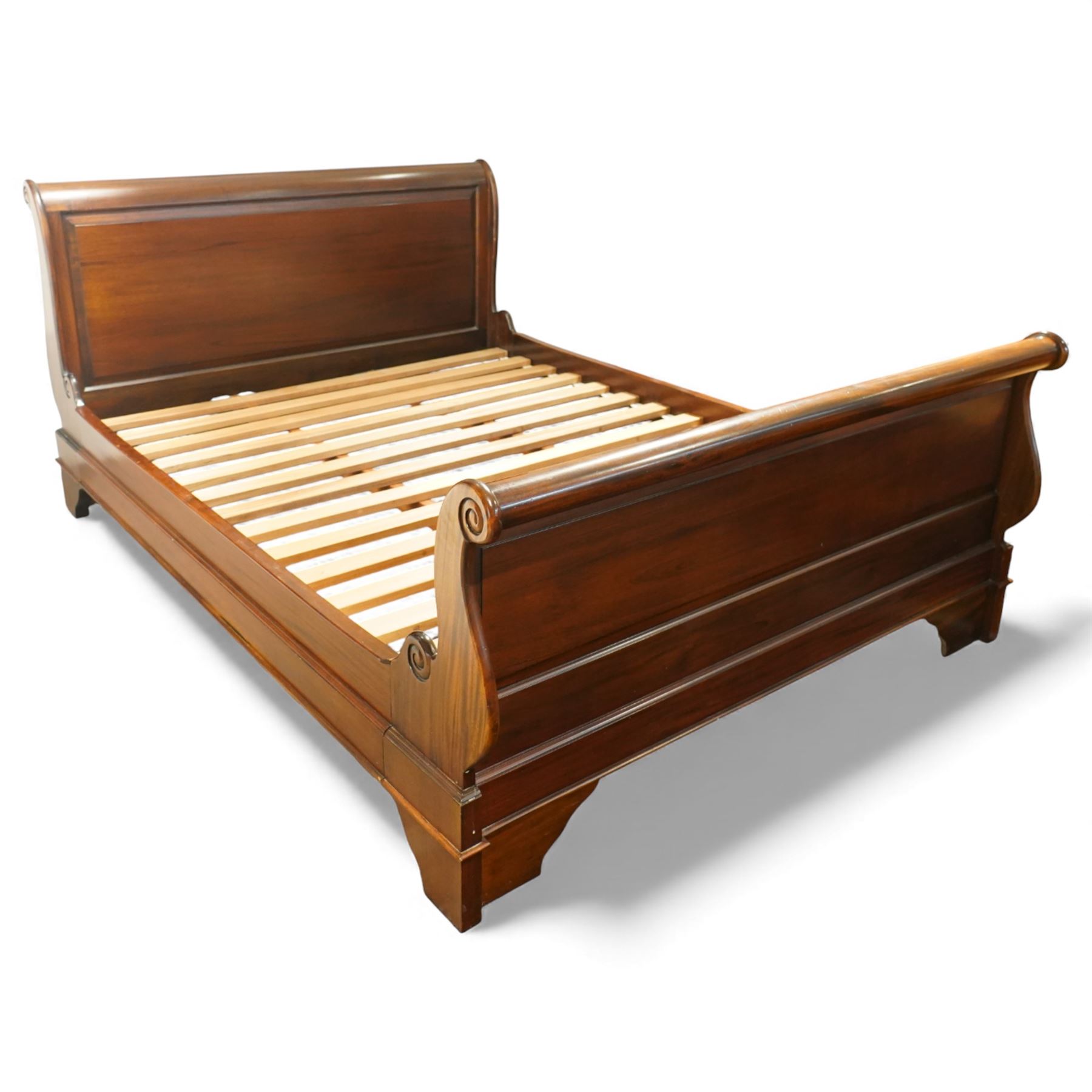Late 20th century French design mahogany king size sleigh bed, the shaped headboard and footboard with scroll carved terminals and panelled fields, over swept side rails, raised on moulded bracket supports