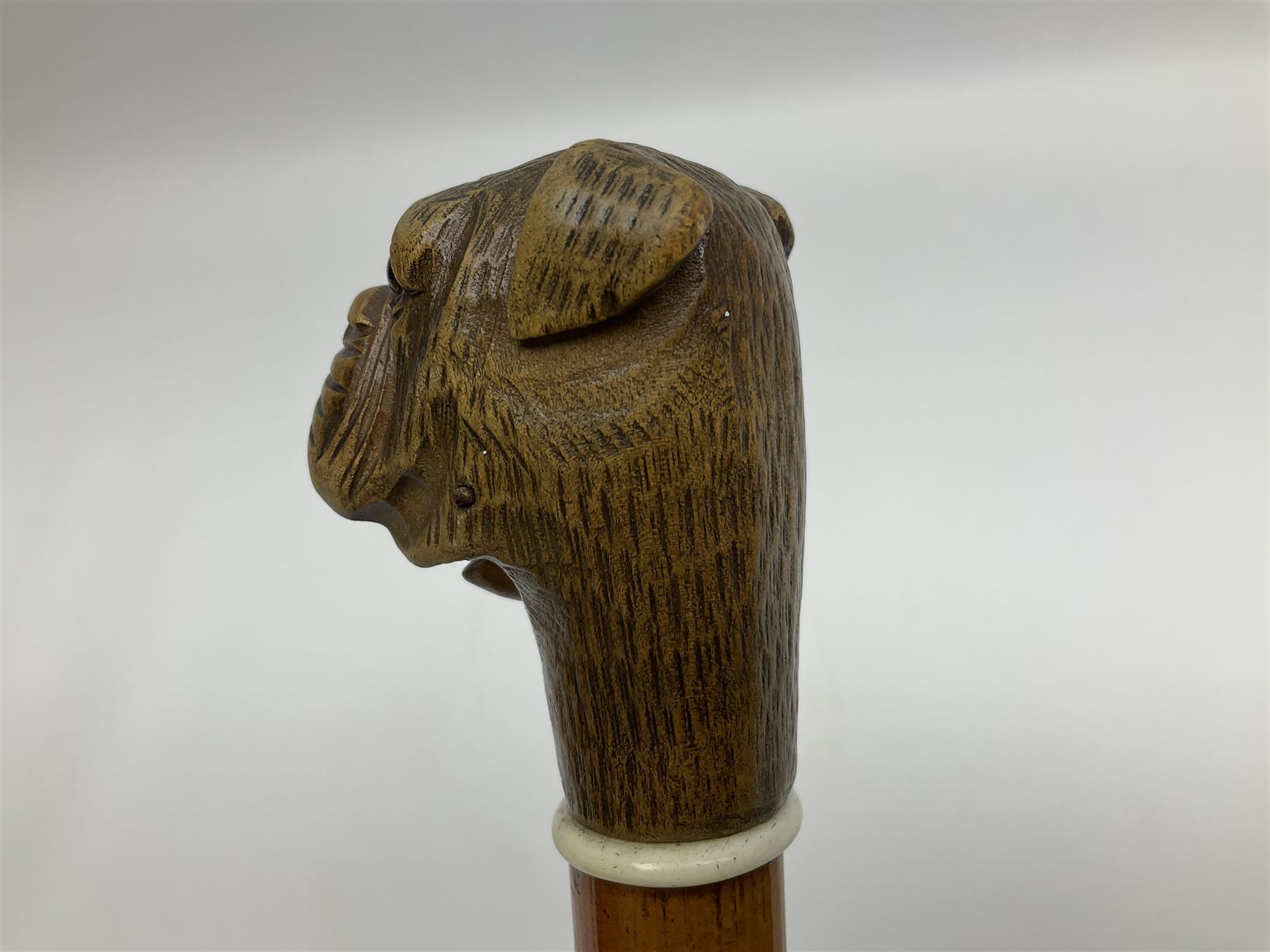 20th century walking cane, the carved wooden handle modelled as the head of a boxer dog with inset glass eyes and articulated and sprung jaw, upon a tapering Malacca shaft, L86.5cm