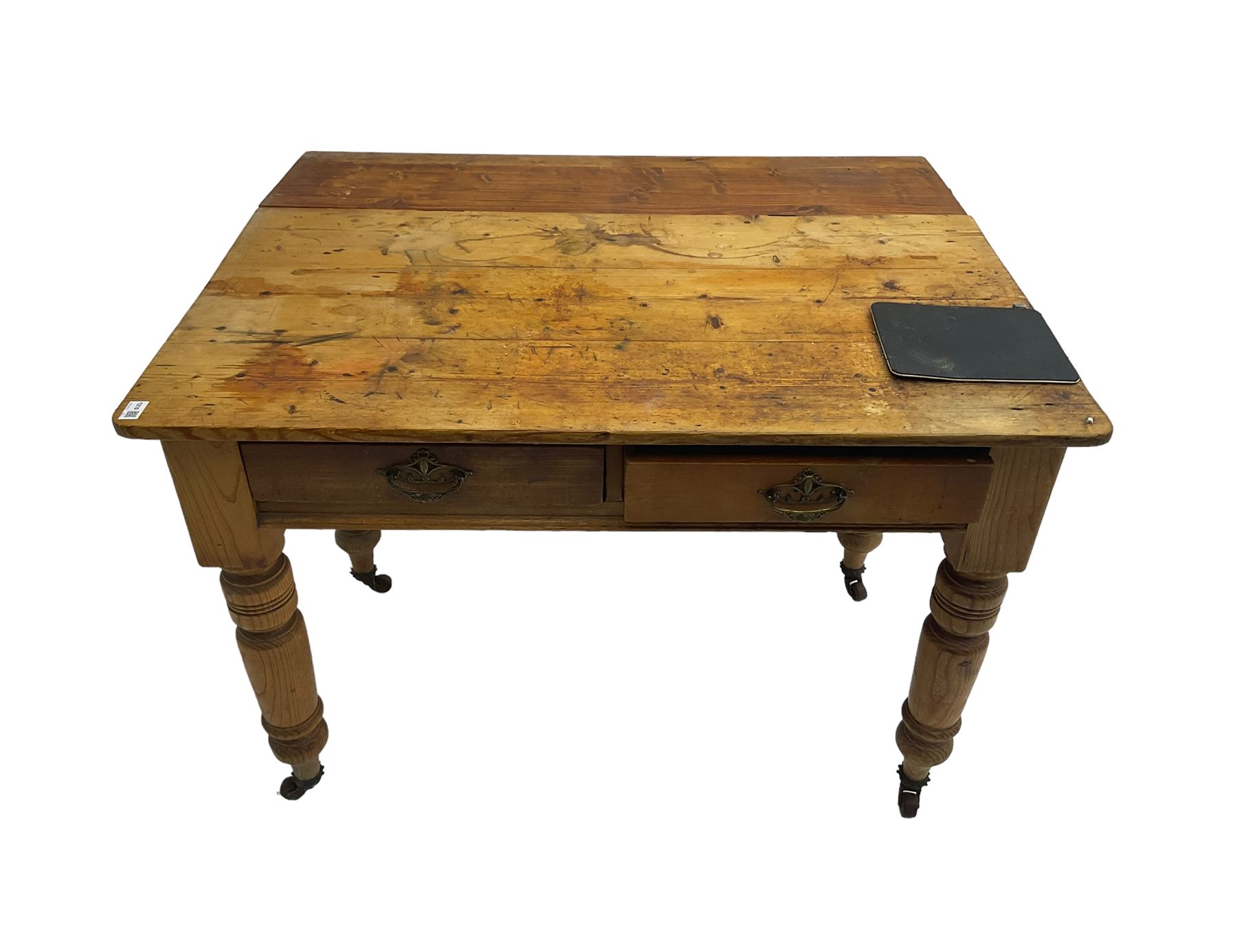 Traditional rustic pine dining table, rectangular top fitted with two drawers, raised on turned tapering supports on ceramic castors