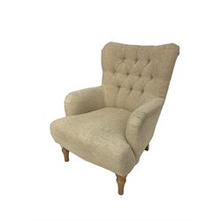 Traditional wingback armchair, upholstered in buttoned fabric with sprung seat, raised on turned supports