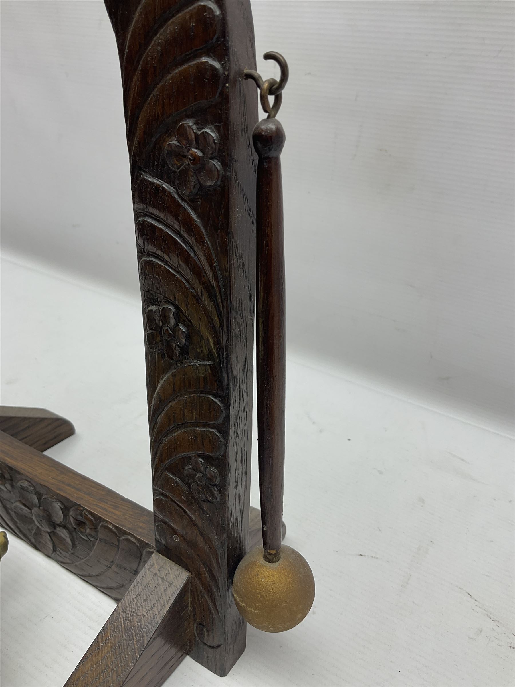 Chinese brass temple bell, decorated in high relief with a a dragon chasing a flaming pearl, within a carved floral hardwood stand, H36cm
