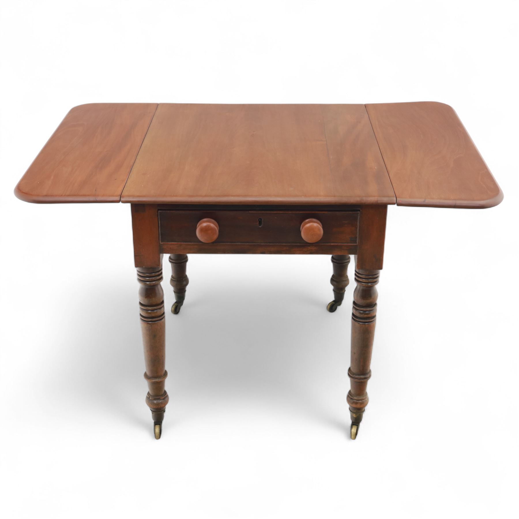 Mahogany drop-leaf Pembroke table circa 1900, with rounded rectangular top and single frieze drawer, raised on turned and tapered supports with brass castors (Extended 128cm)