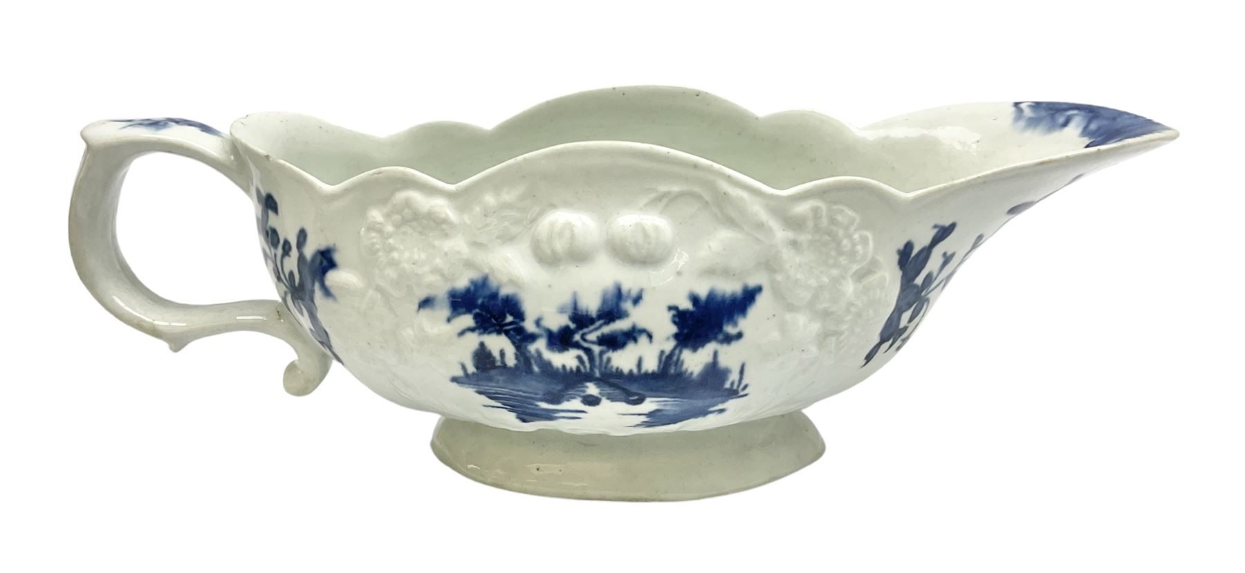 Large 18th century Lowestoft sauce boat, circa 1770, the body decorated with Hughes type floral moulding, and painted in underglaze blue with an Oriental landscape, and foliate sprigs, L23cm