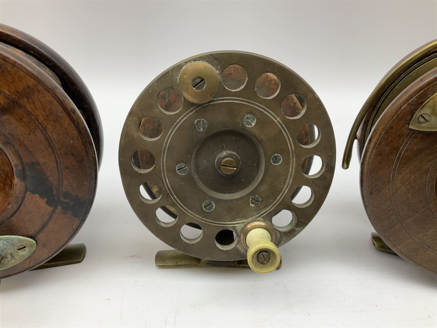 Three Allcocks & Co Ltd reels of brass and wood construction, the largest D4.5 inches