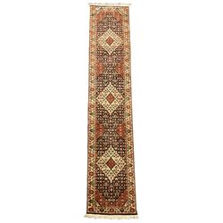 Persian design indigo ground runner, the field decorated with three floral lozenge medallions, decorated all over with small flower heads, repeating border