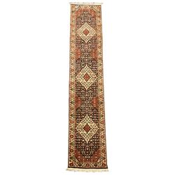  Persian design indigo ground runner, the field decorated with three floral lozenge medallions, decorated all over with small flower heads, repeating border