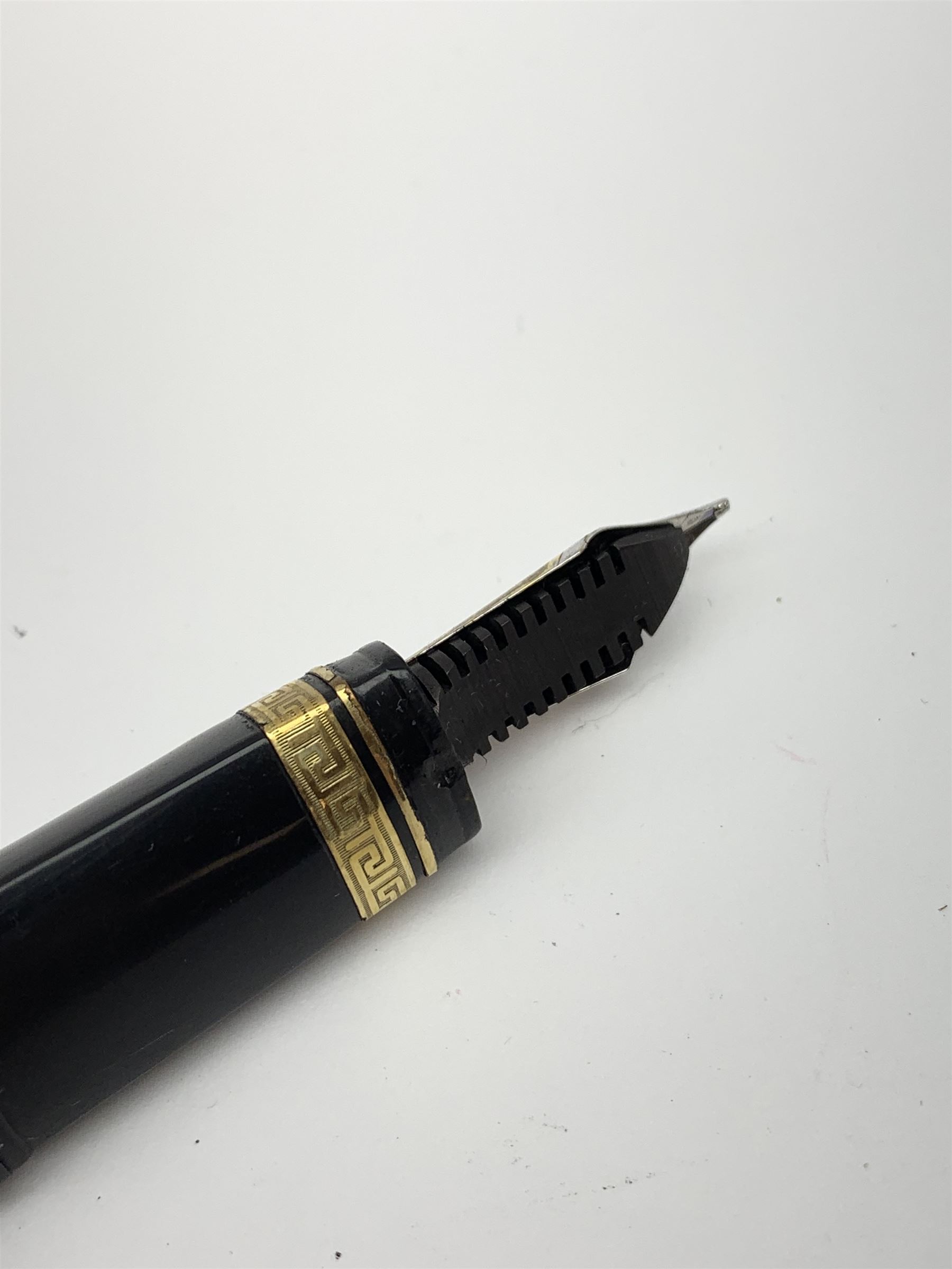 An Omas 360 fountain pen, the black triangular section body with gold coloured clip and banding, and Greek Key border to the cap, the bicolour nib marked 750 18K.