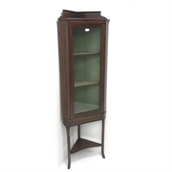  Edwardian inlaid mahogany corner display cabinet, raised shaped back, single glazed doors enclosing two shelves, three tapering supports joined by single undertier, W54cm, H169cm, D32cm  
