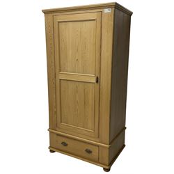 Waxed pine single wardrobe, panelled door enclosing hanging rail, single drawer fitted to base, on compressed bun feet