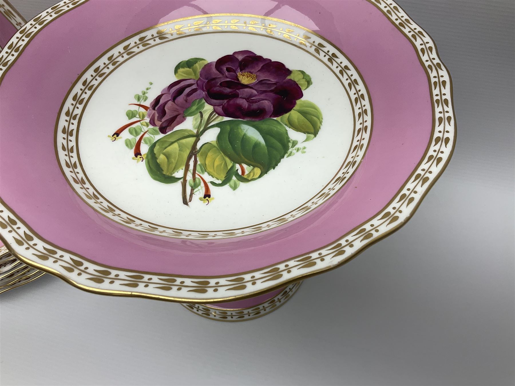 Victorian Copeland, Botanical dessert service, decorated with floral sprigs to the centre with a pink and gilt border, comprising five comports and seven plates, largest comport H20cm, plate D22cm
