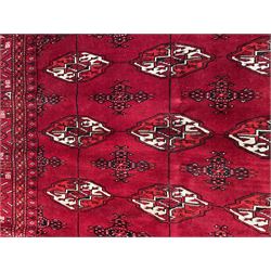 Turkman Bokhara red ground rug, decorated with Gul motifs, repeating guarded border with stylised motifs