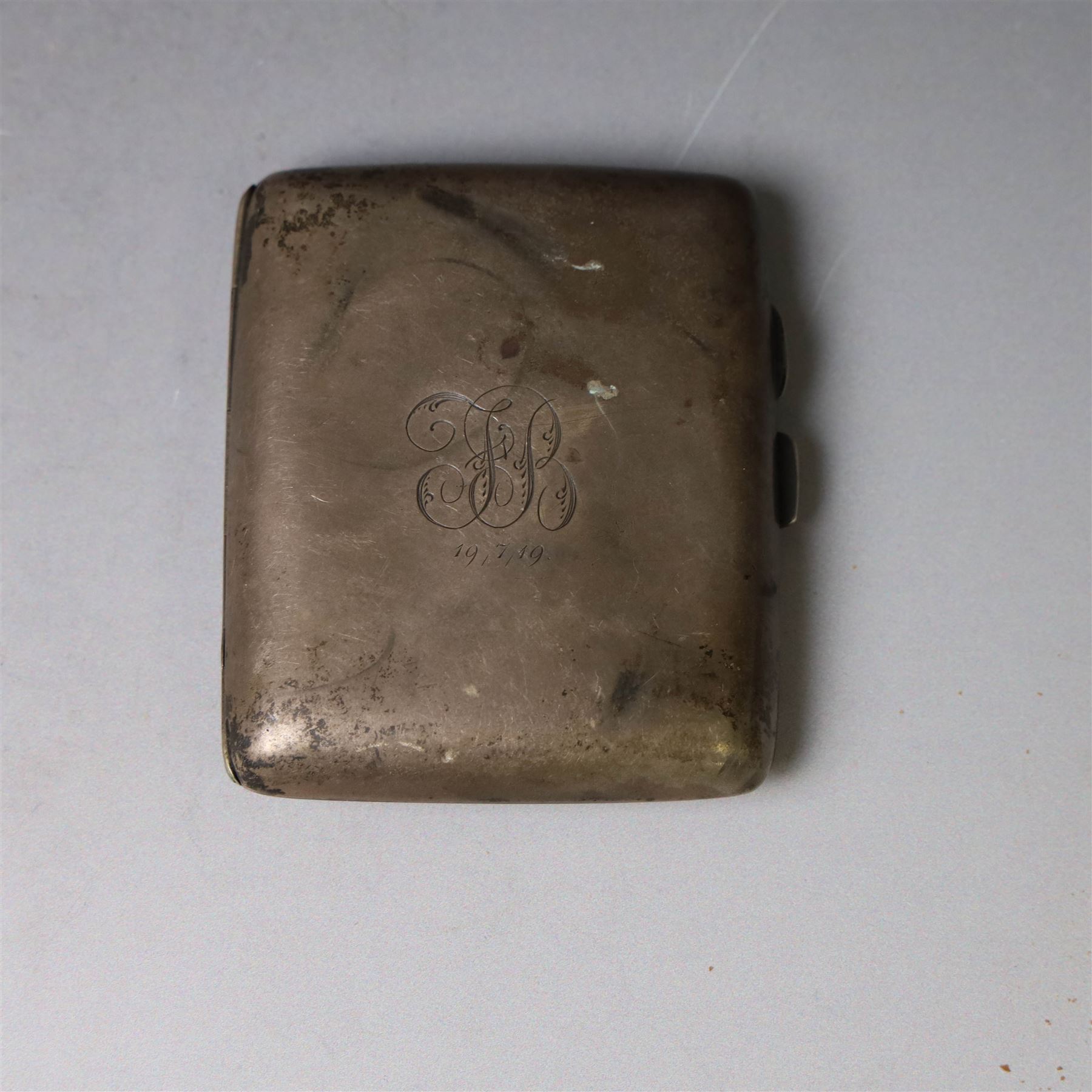 1960s silver compact mirror, of circular form with engine turned and engraved foliate decoration to lid, hallmarked Kigu Ltd, London 1963 and an early 20th century silver cigarette case with engraved monogram to cover, hallmarked A J Pepper & Co, Birmingham 1918