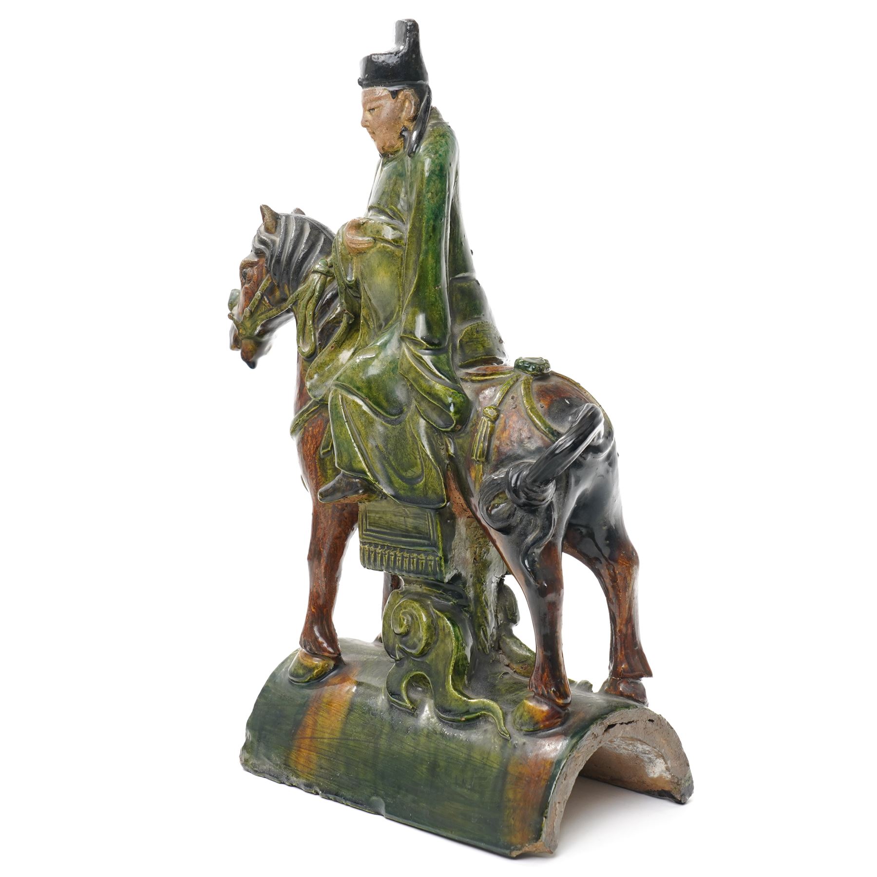 Chinese Ming dynasty Sancai Glazed Roof Tile, modelled as a dignitary on horseback, dressed in a long robe with voluminous folds, wearing an official's cap, upon a half cylinder tile, H40cm