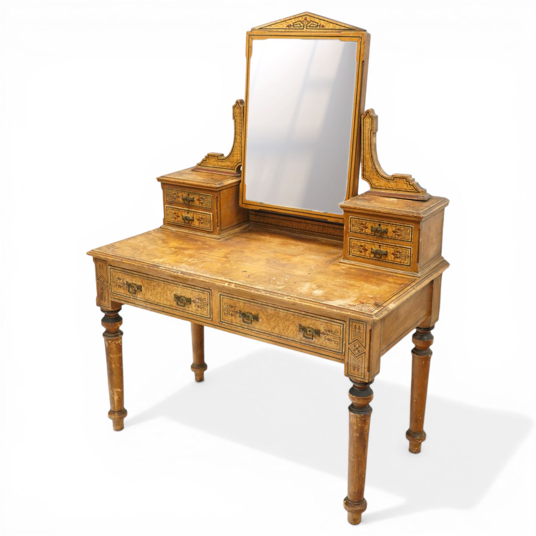 Late Victorian Aesthetic Movement scumbled and painted pine dressing table, arched swing mirror over four small trinket drawers, decorated with painted ebonised stringing and Aesthetic Movement motifs, rectangular top fitted with two drawers, on turned supports