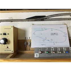 'Z' gauge continental scenic layout with folding legs, various loops of track and sidings with overhead cables, buildings including water tower, tunnels, roads with motor vehicles and figures, trees, haven with boats, backdrop diving wall hiding control units 150 x 50cm