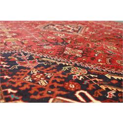 Persian tribal hand-knotted rug, crimson ground, madder field with central stepped lozenge medallion with scattered floral and geometric spandrels with rosette border 