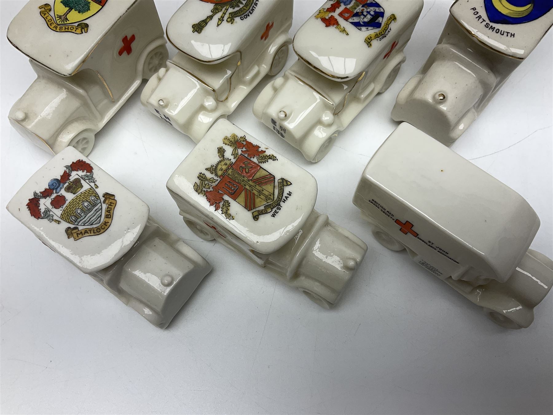 Ten WW1 crested china military models comprising seven field ambulances and three 'Home Fires Burning' fire-surrounds/range; various makers including Willow Art, Arcadian China, Grafton China, Savoy China, Carlton China etc; various crests including Devon, Aldershot, Portsmouth, West Ham, Coventry, Oxford, Hastings, Brighton etc (10)