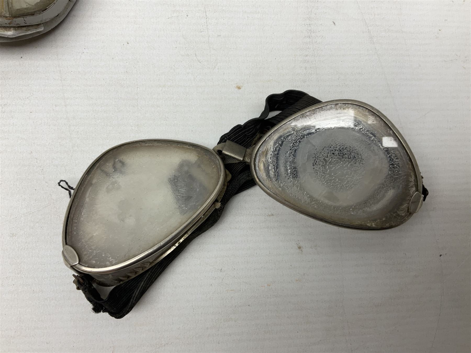 Two Geno Paris small size motorcycle helmets; and three pairs of goggles, one marked 'Stadium'