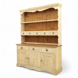 20th century painted pine dresser, moulded cornice above shaped frieze and two open plate shelves, central row of five small drawers with wooden knobs, base fitted with three drawers over a pair of panelled cupboard doors, on shaped plinth base