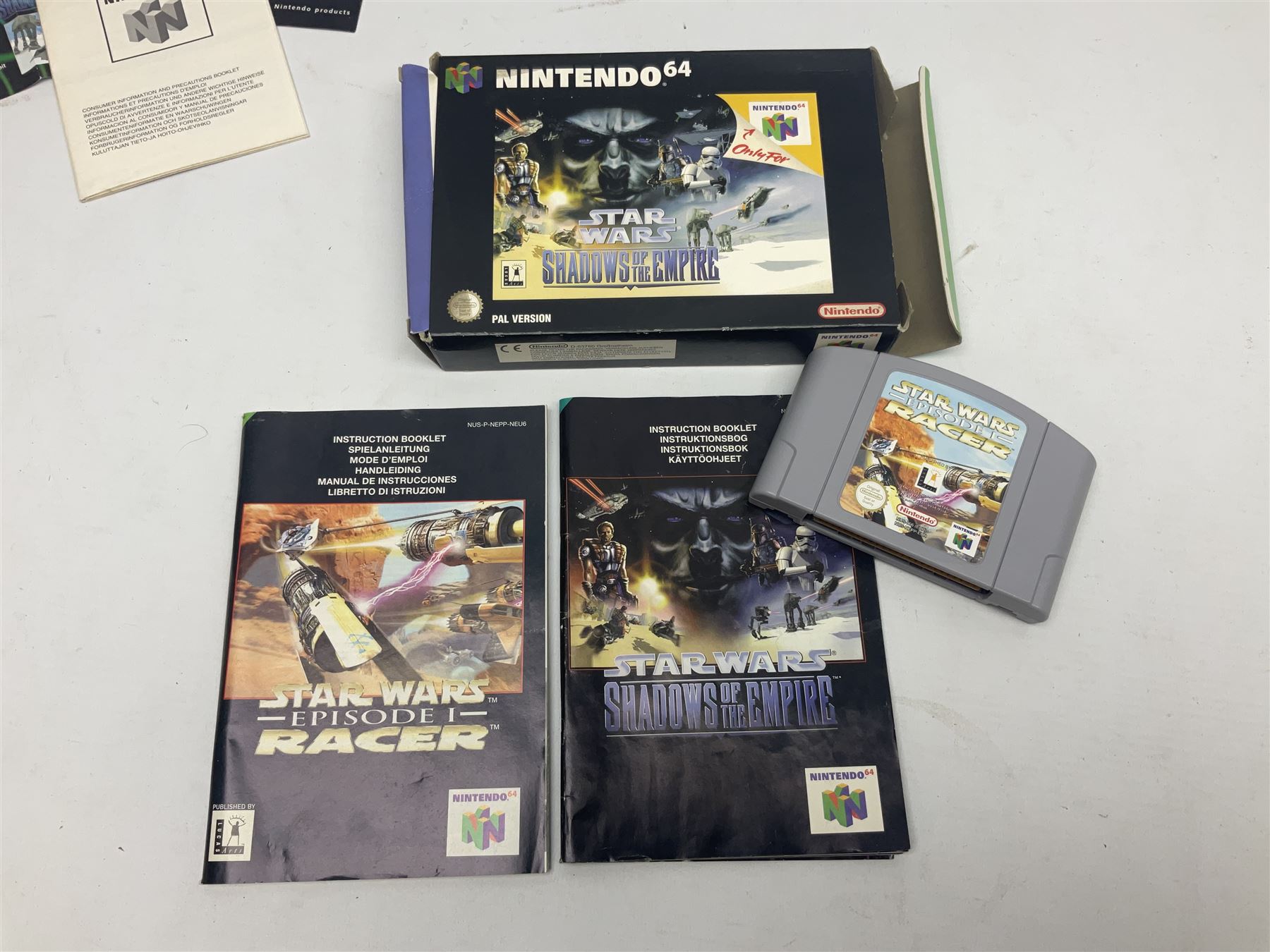 Nintendo 64 console, two controllers, games and accessories. Accessories to include the ‘Tremorpak’ and ‘Spook’ 2 Phono plugs and a S-VHS plug with adapter, both in original boxes. Games to include ‘Golden Eye 007’, ‘Doom 64’, ‘Killer Instinct Gold’, ‘Tetrisphere’, ‘F-1 World Grand Prix’, ‘Pilotwings 64’ and ‘Lylatwars’ with ‘Rumble Pak’, all with original boxes and instruction manuals. ‘Star Wars Episode I Racer’ game cartridge in Shadows of the Empire box. 