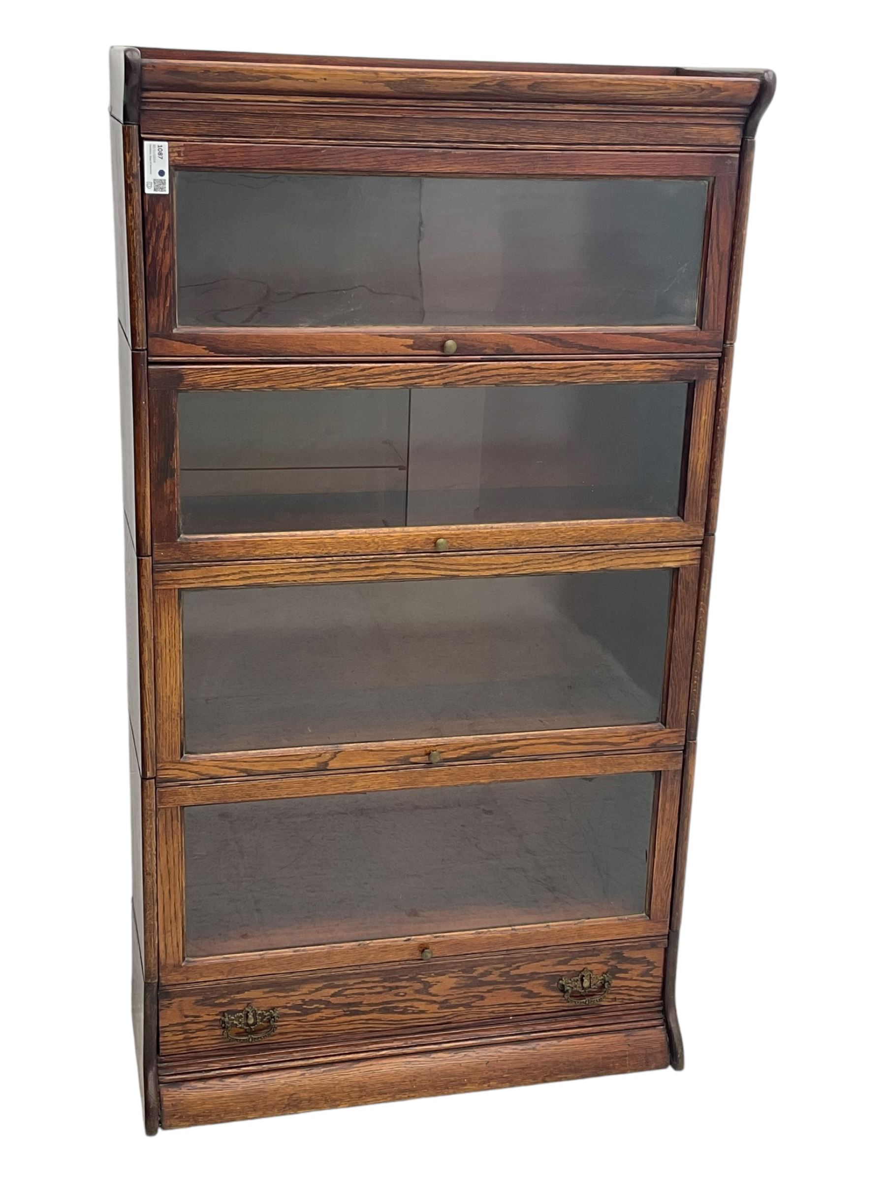 Early 20th century oak stacking library bookcase, four sections enclosed by hinged and sliding glazed doors, fitted with single drawer 