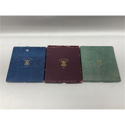 Three King George VI 1951 'Festival Of Britain' specimen coin sets, each comprising farthing to crown coins, housed in maroon, green and blue dated boxes 